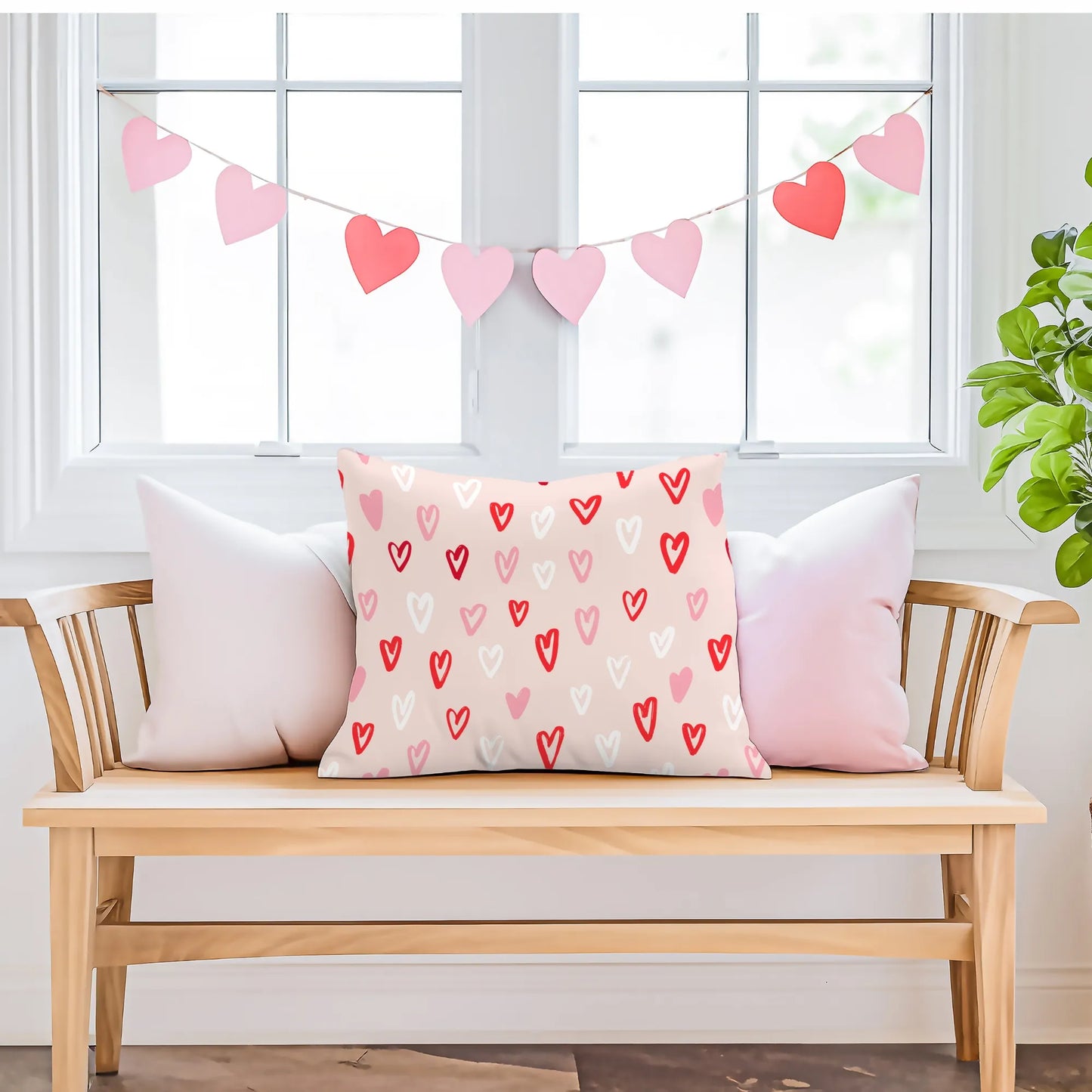 Cute hand-drawn hearts valentine pillow on a cozy bench with heart garland.