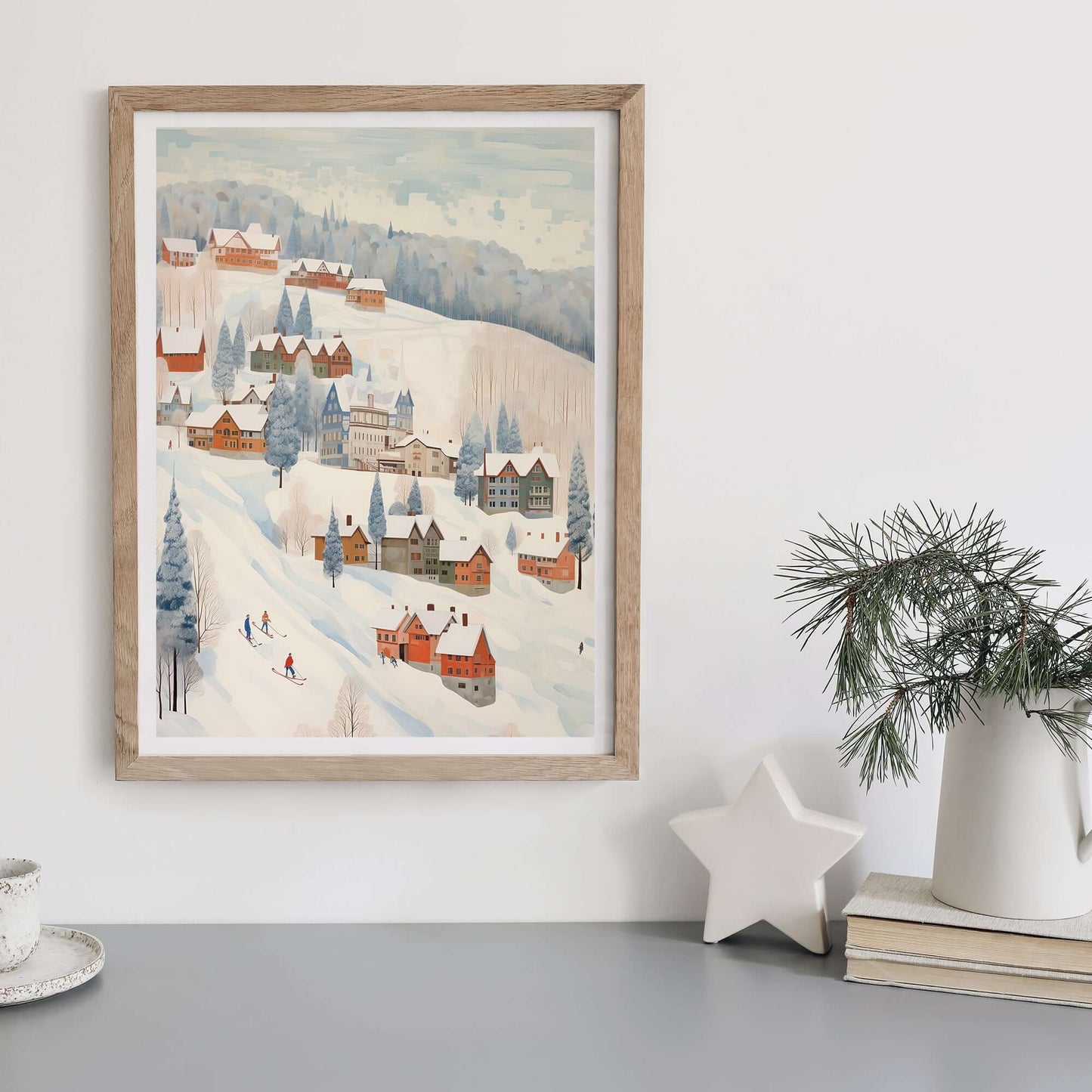 Cute Winter Village Art print displayed in a wooden frame, showcasing a snowy village scene for festive decor.
