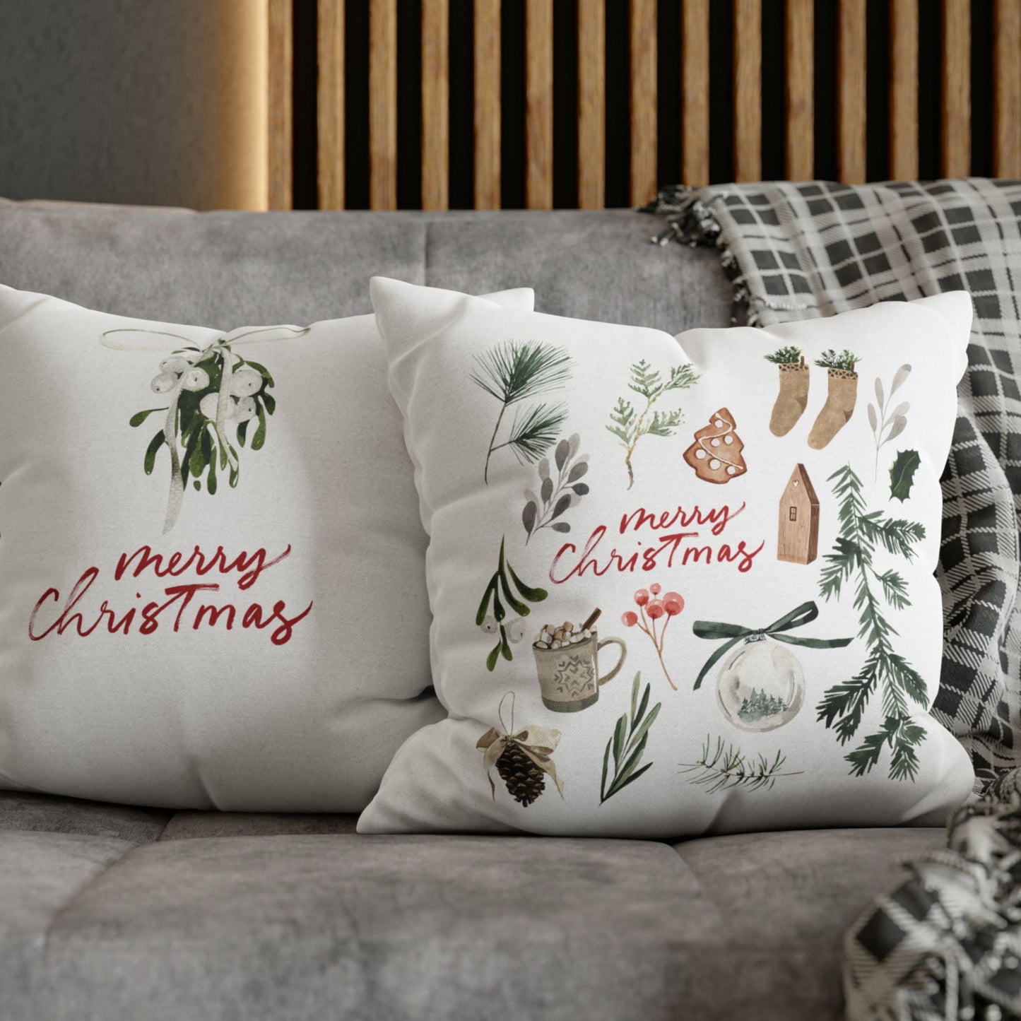 Double-sided Merry Christmas watercolor pillows styled on grey sofa with festive mistletoe and holiday icons