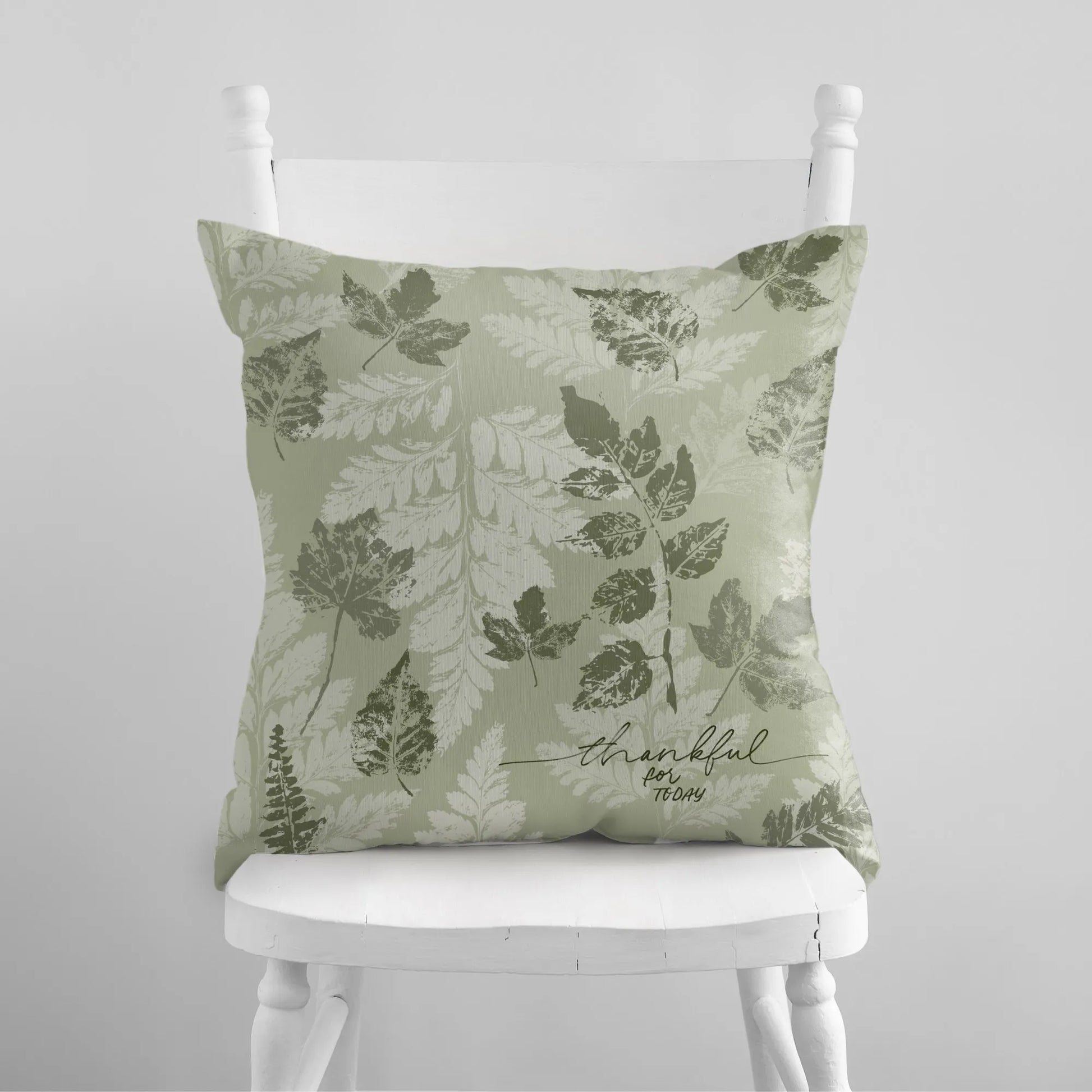 white chair with Autumn Leaves Green PILLOW & COVER from Blue Water Songs on it