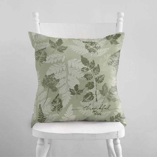 white chair with Autumn Leaves Green PILLOW & COVER from Blue Water Songs on it