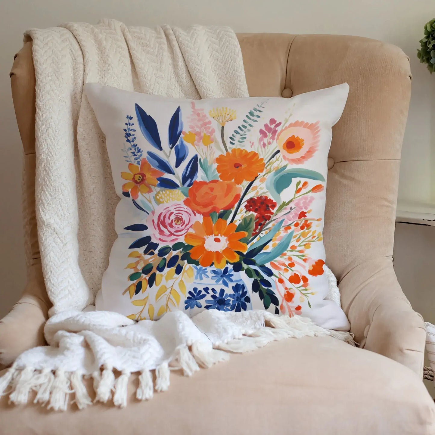 Fall floral pillow cover with vibrant autumn blooms in warm tones on a cozy chair.