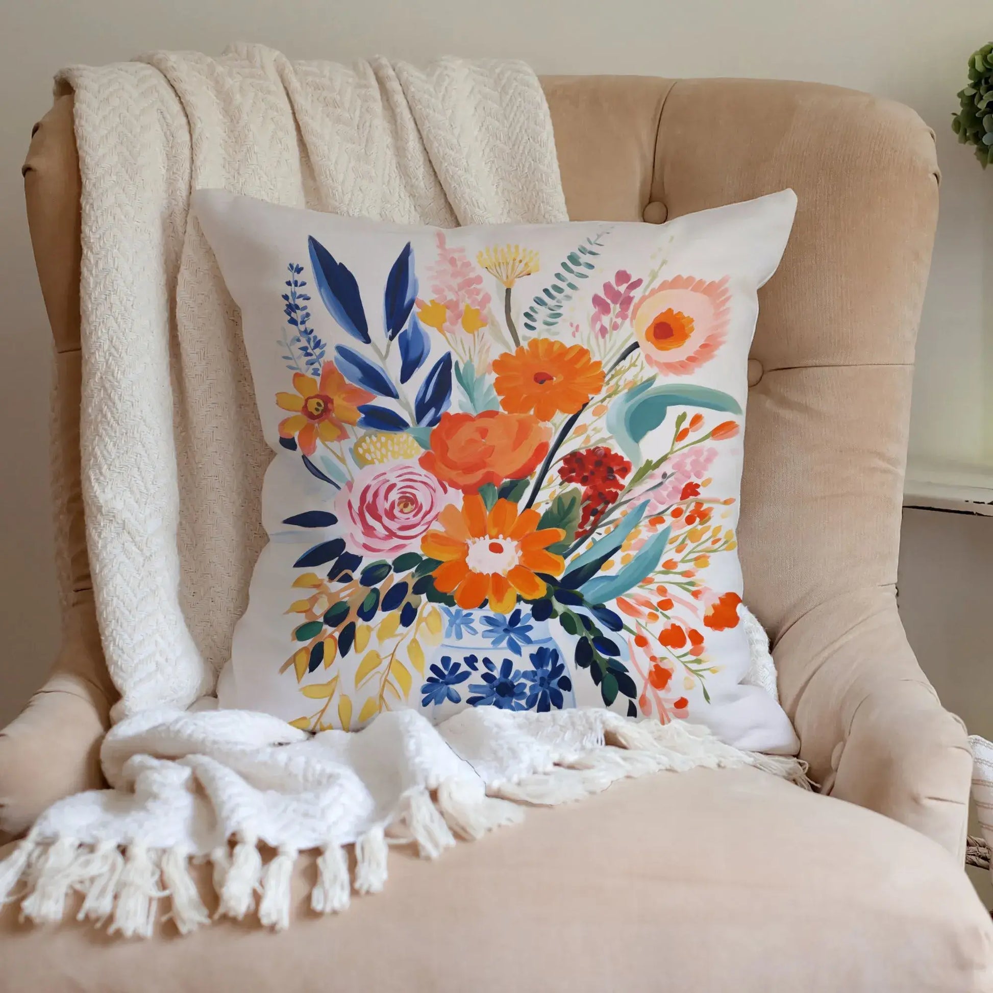 Fall floral pillow cover with vibrant autumn blooms in warm tones on a cozy chair.