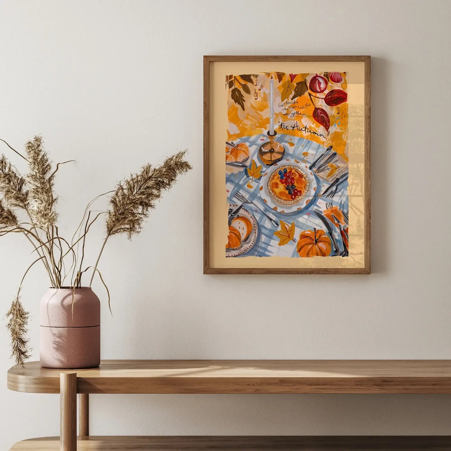 Framed fall wall art with pumpkins and autumn harvest table scene styled above a wooden console with vase decor