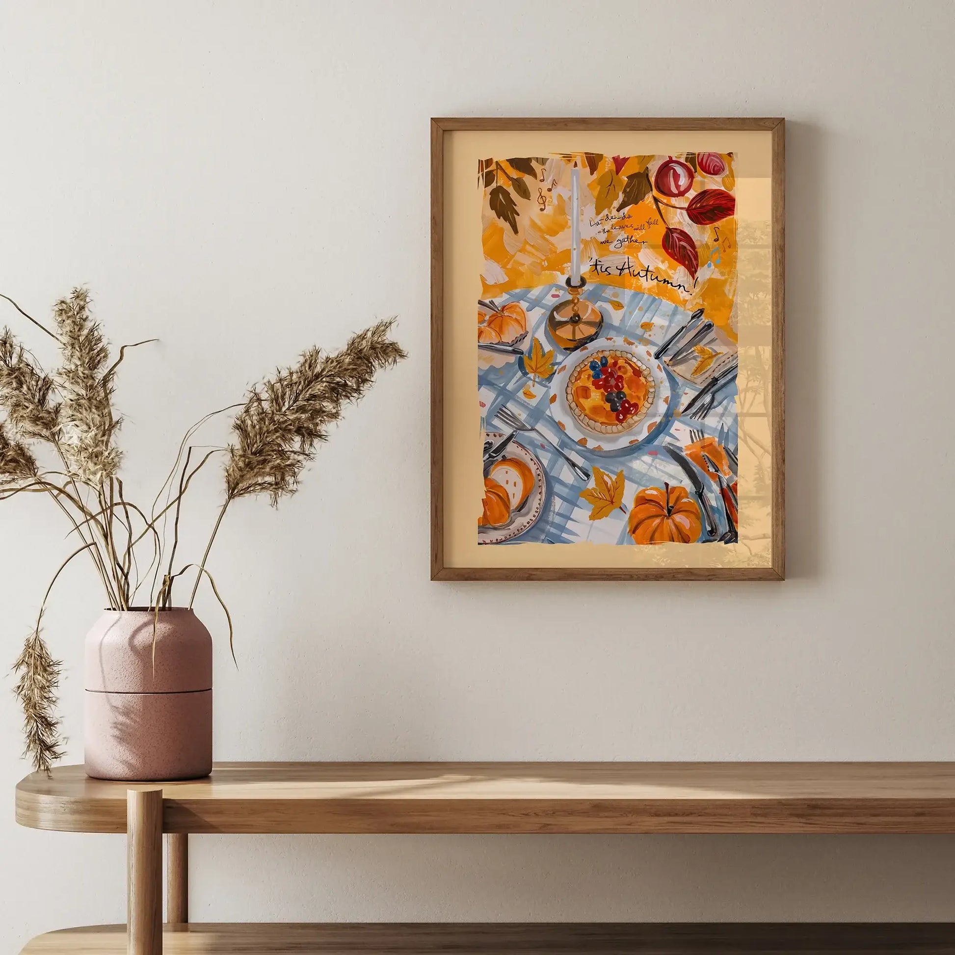 Framed fall wall art with pumpkins and autumn harvest table scene styled above a wooden console with vase decor