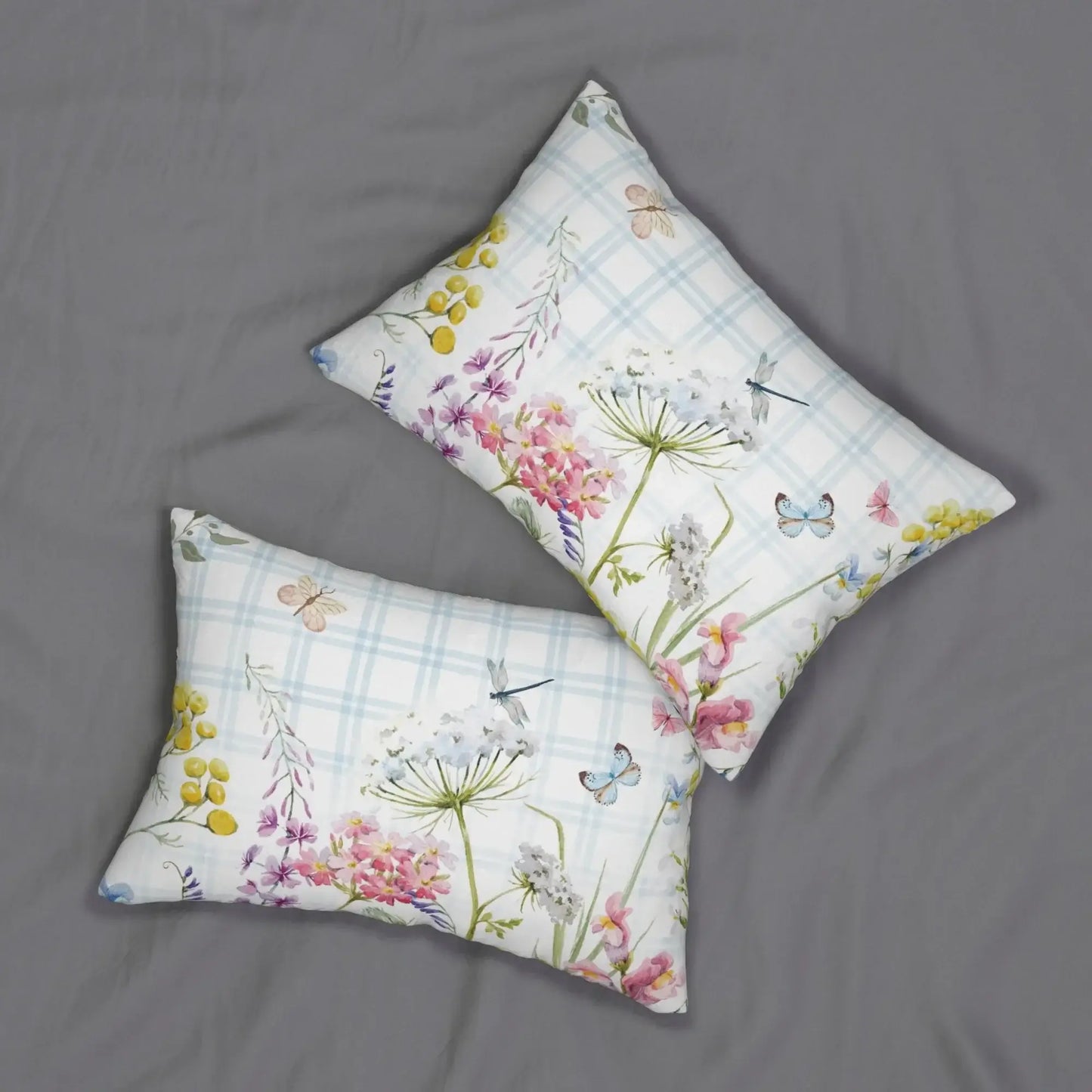 Floral lumbar pillows with wildflowers and butterflies on blue plaid, ideal for spring decor and nature-inspired bedrooms.