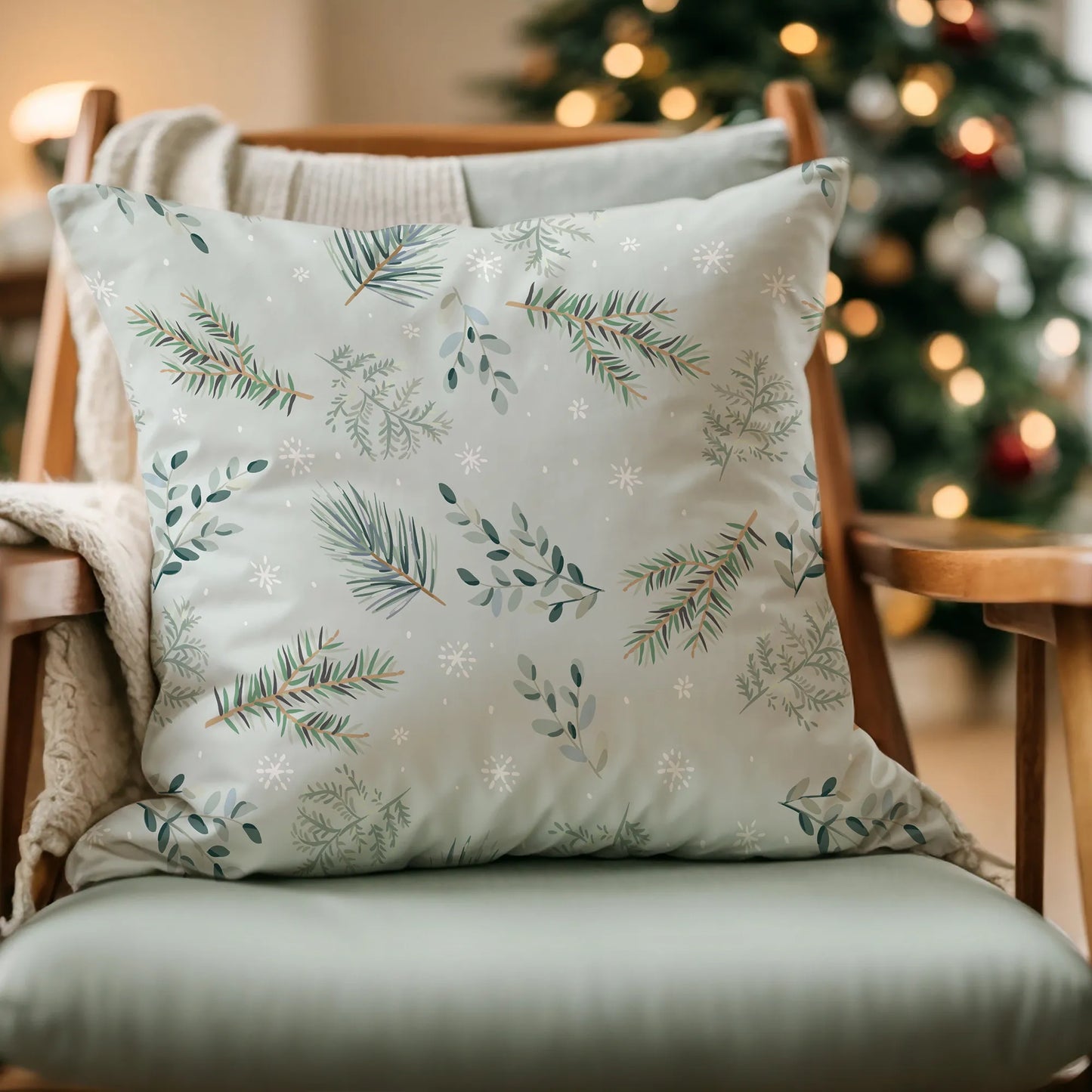 light green pine winter pillow from Blue Water Songs on wood chair with christmas tree in the background