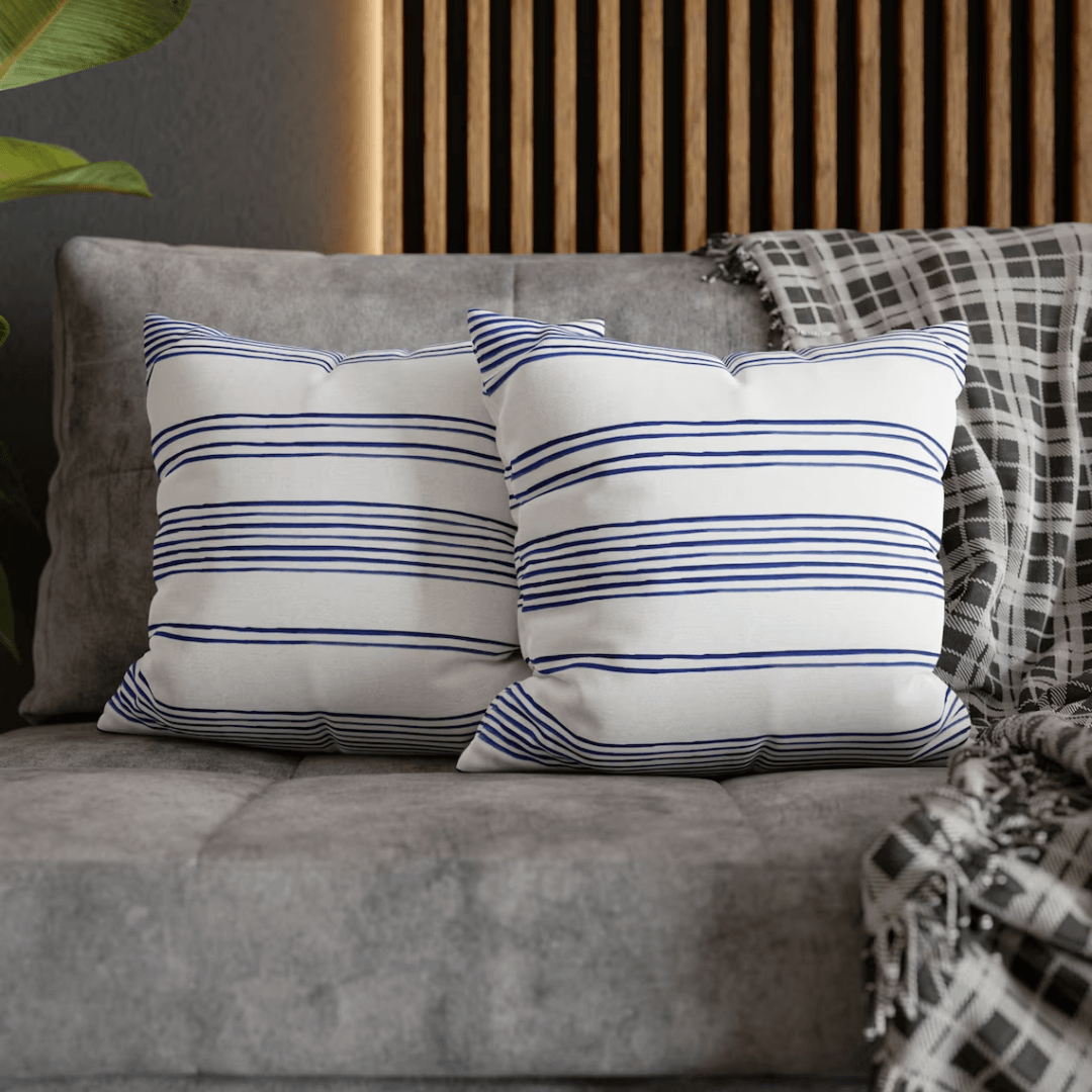 Hamptons Striped Pillow on a sofa, featuring blue and white stripes for coastal home decor.