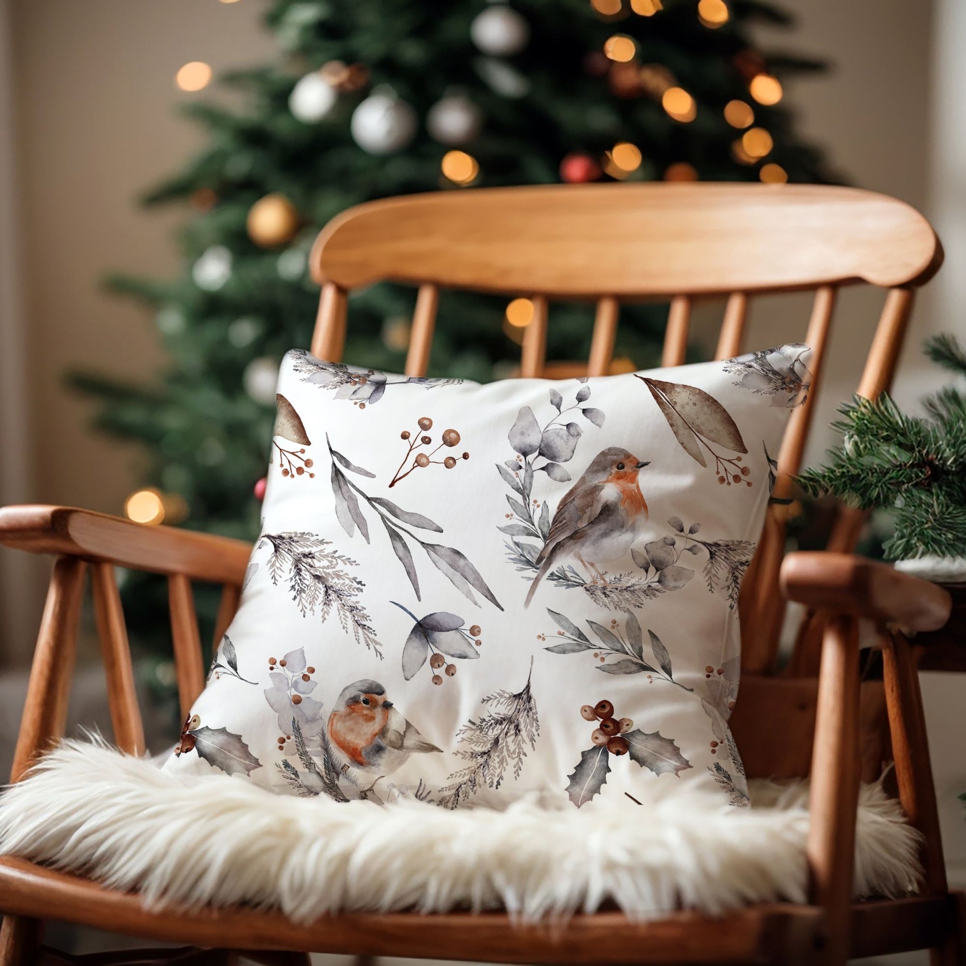 Christmas pillow with watercolor robin bird on wooden rocking chair in front of tree