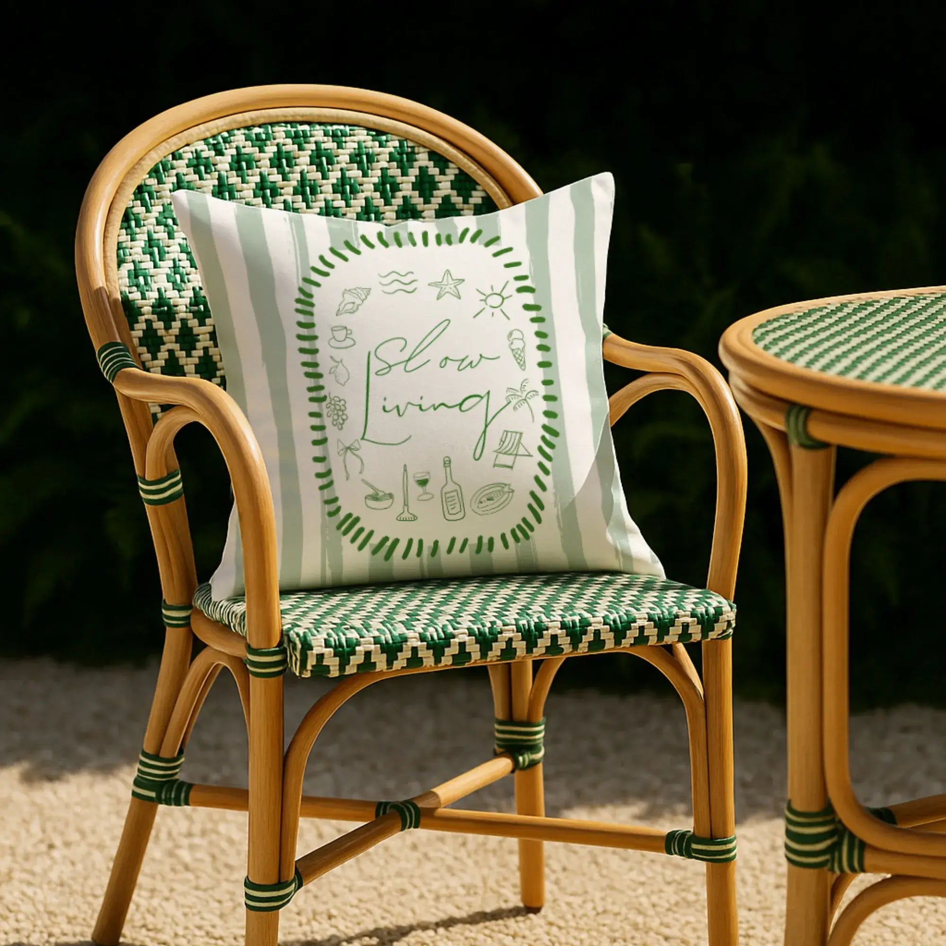 La Dolce Vita Pillow Cover on a rattan chair with green and white stripes, perfect for summer decor.