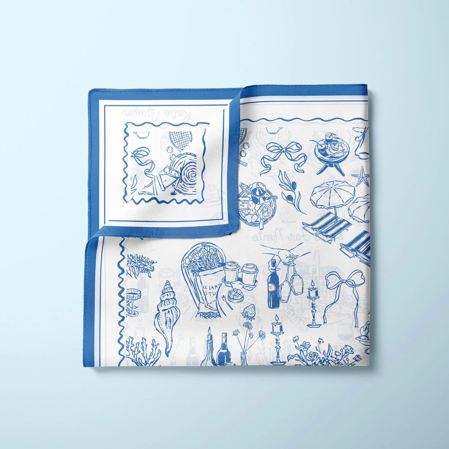 The Dolce Moment Silk Scarf folded flat – blue and white coastal picnic and floral print on light background.