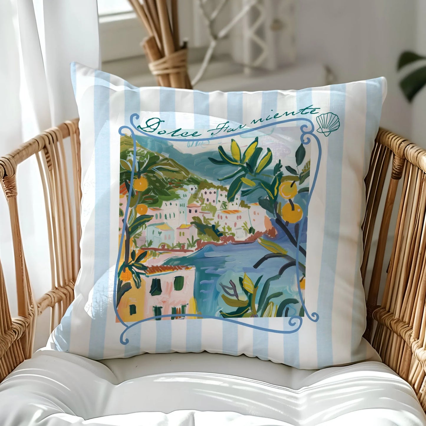 “Dolce Far Niente” lemon and coastal print pillow styled on a wicker chair by a sunlit window — soft blue stripes and Amalfi-inspired summer decor.