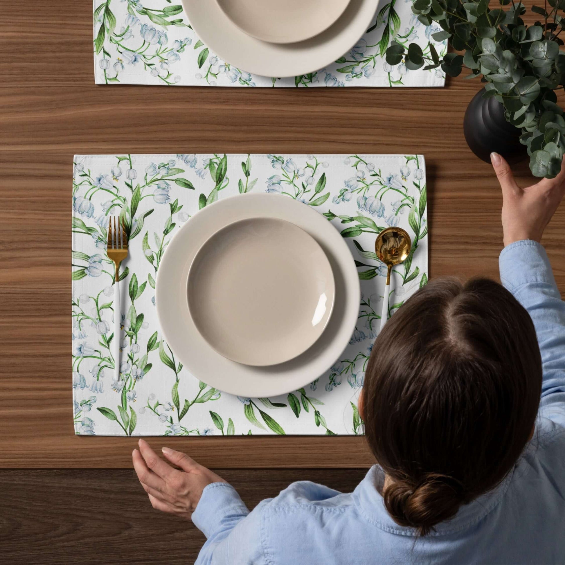 Lily Of The Valley PLACEMAT Set displayed on a wooden table with plates and cutlery for a serene dining experience.