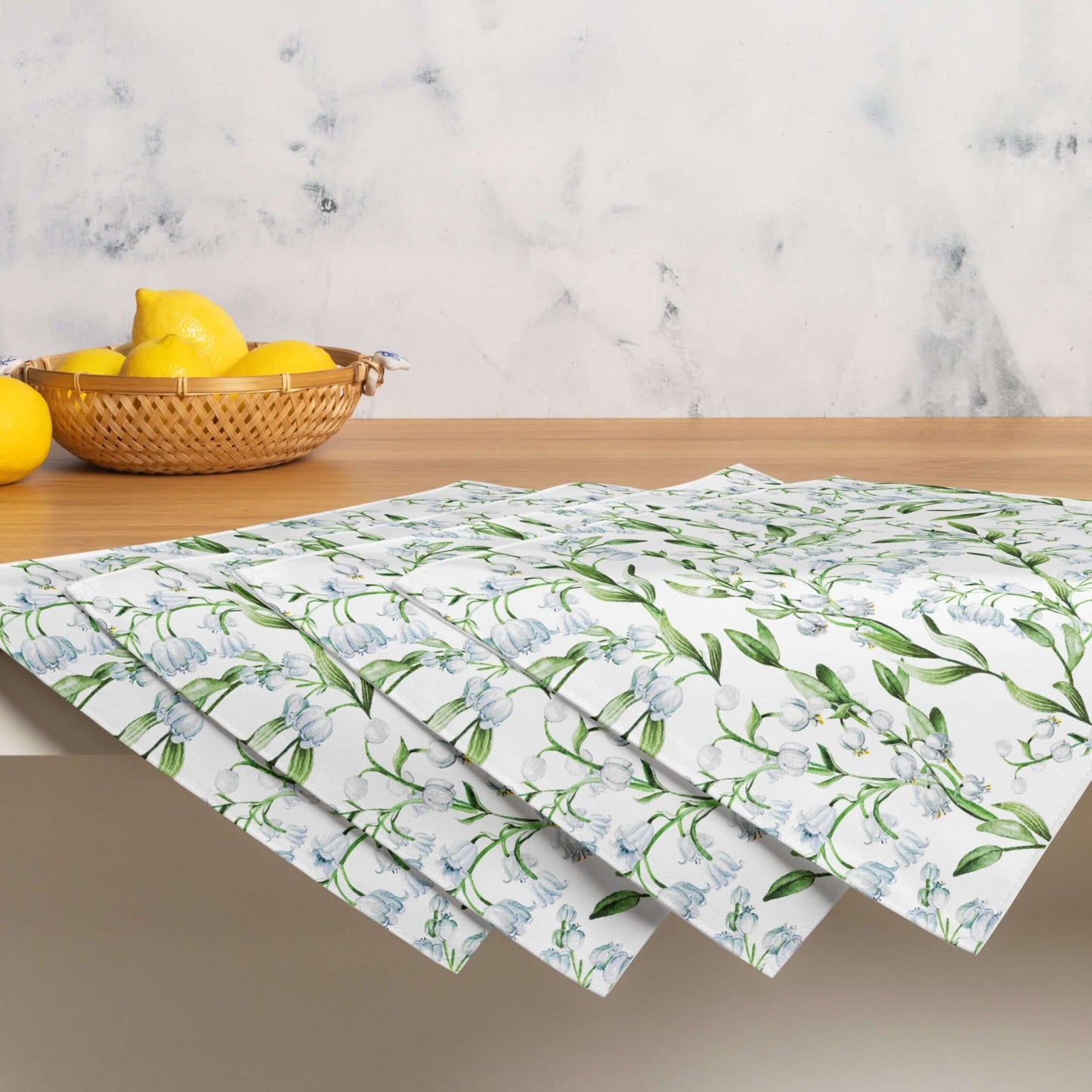 Lily Of The Valley PLACEMAT Set displayed on a table with a bowl of lemons, showcasing its elegant floral design.