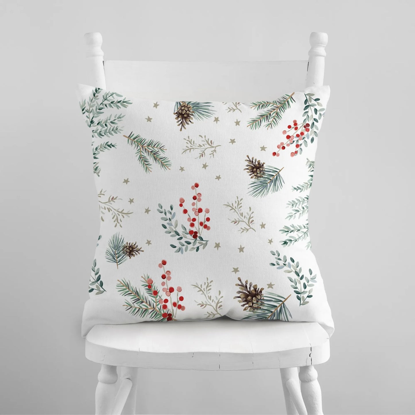 Back of Merry Holiday pillow with pine branches, red berries, pinecones, and gold star accents – festive Christmas design