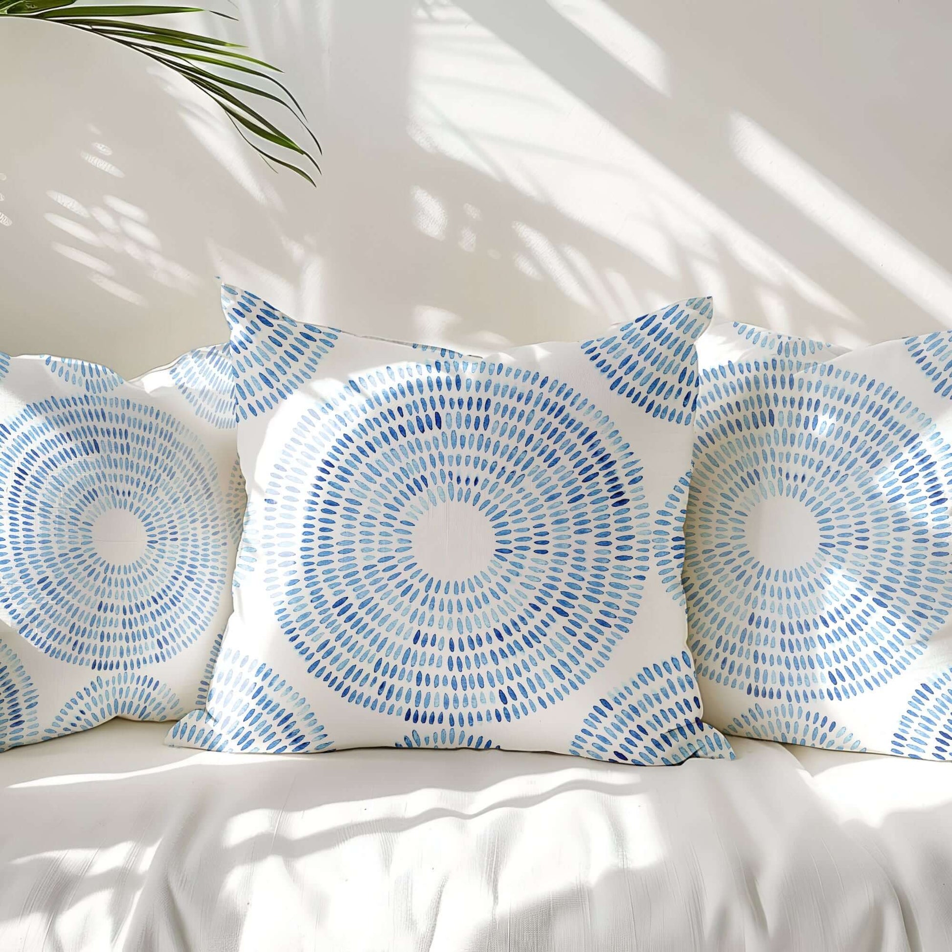 3 blue pillows on white sofa