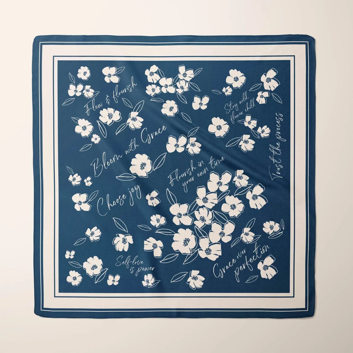 Deep blue silk scarf with white minimalist wildflowers and inspirational quotes like "Bloom with Grace" and "Choose joy".