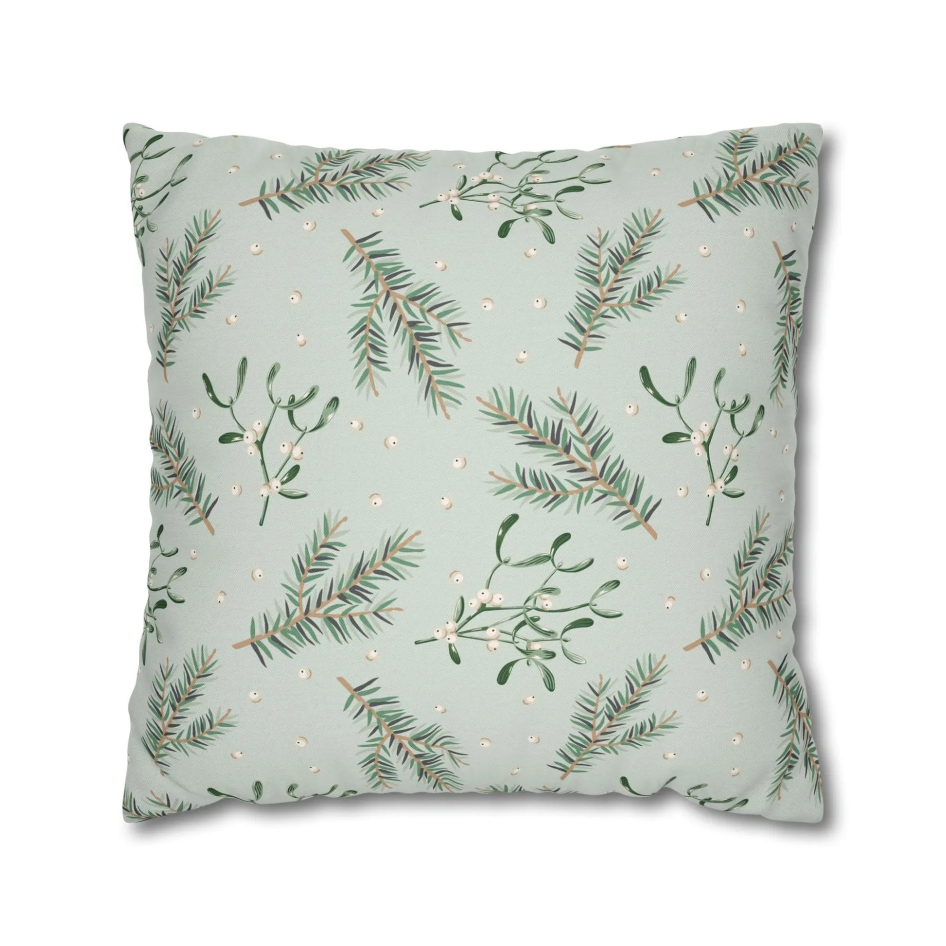 Flat lay of botanical mistletoe Christmas pillow with pine branches and white berries on soft green background