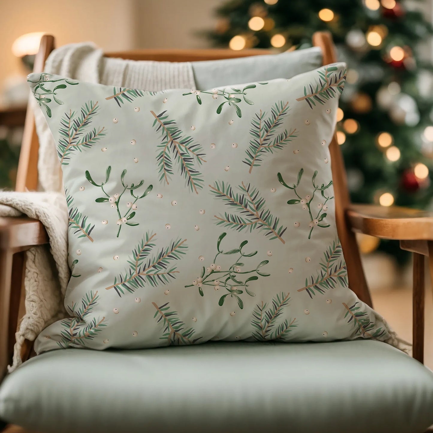 Mistletoe Christmas pillow on armchair with holiday lights – soft botanical decor for cozy seasonal styling