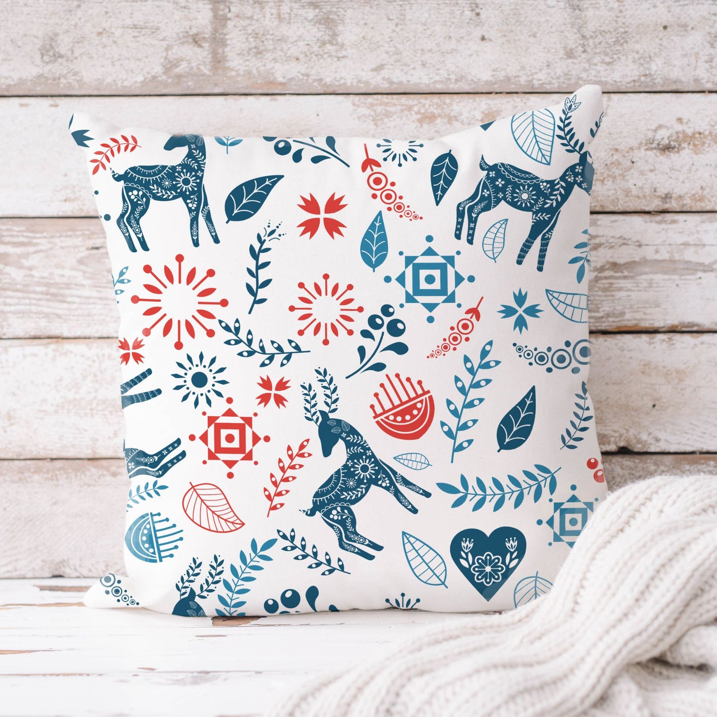 Reindeer Christmas Pillow cover featuring stylized reindeer and bold Scandinavian floral patterns in blue and red.
