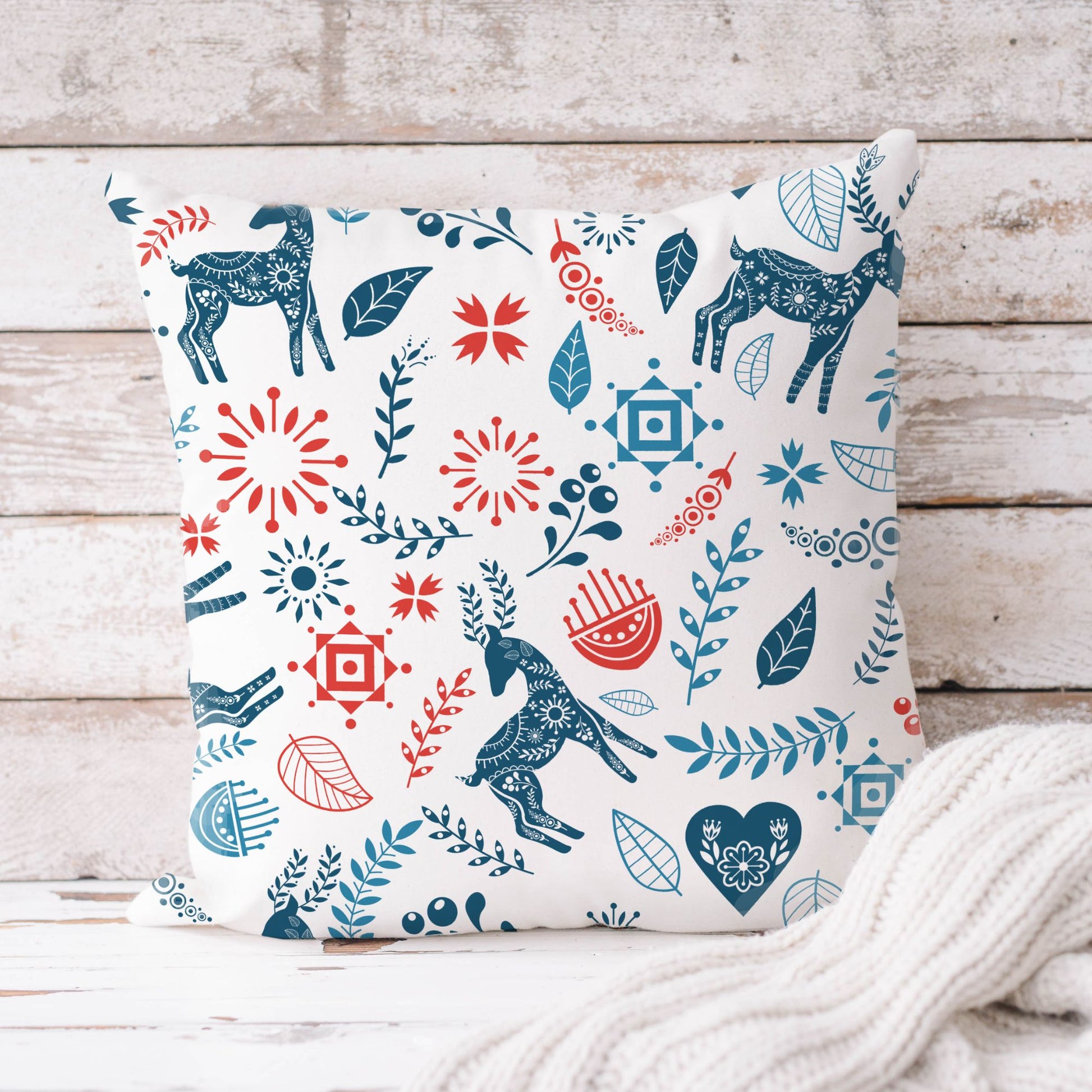 Reindeer Christmas Pillow cover featuring stylized reindeer and bold Scandinavian floral patterns in blue and red.