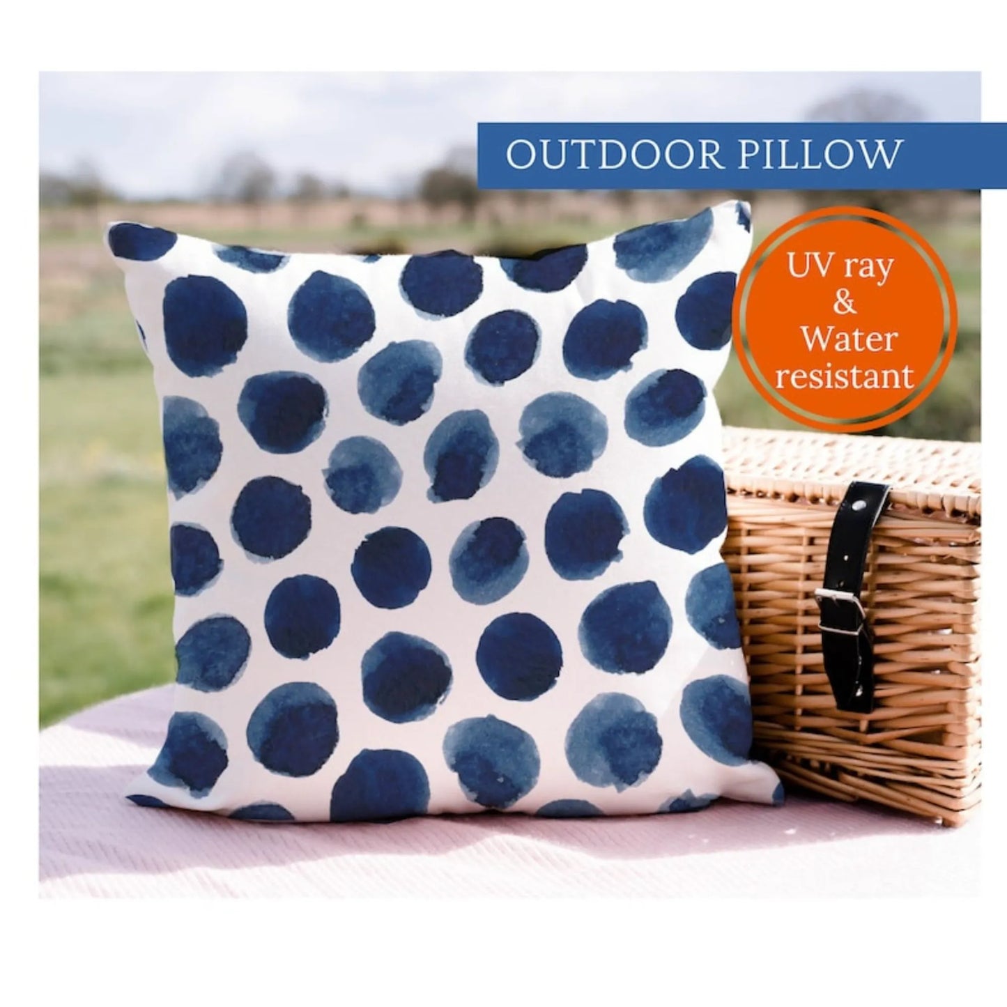 Watercolor Navy and White OUTDOOR PILLOW sitting on picnic blanket
