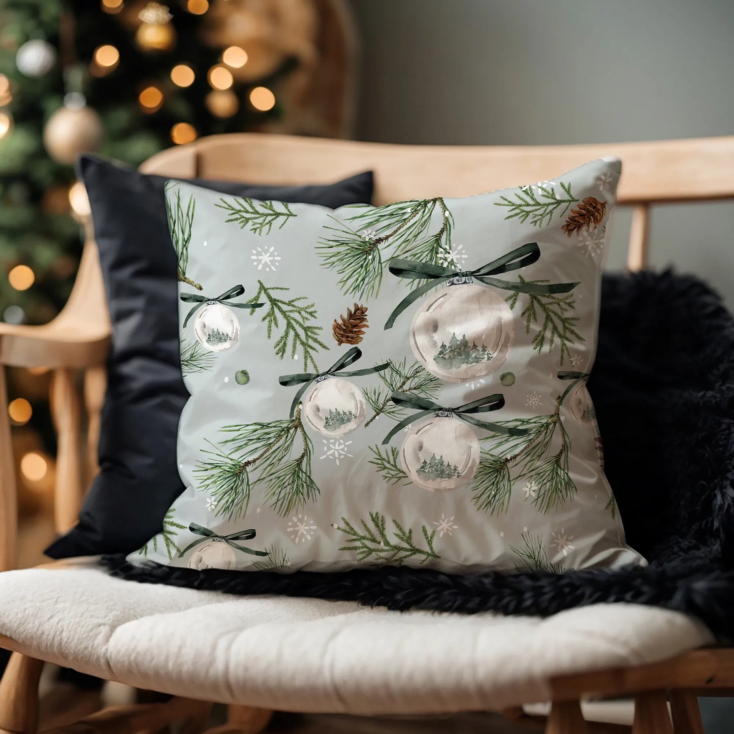 Watercolor pine Christmas pillow on wooden bench with black cushion – festive nature-inspired holiday decor