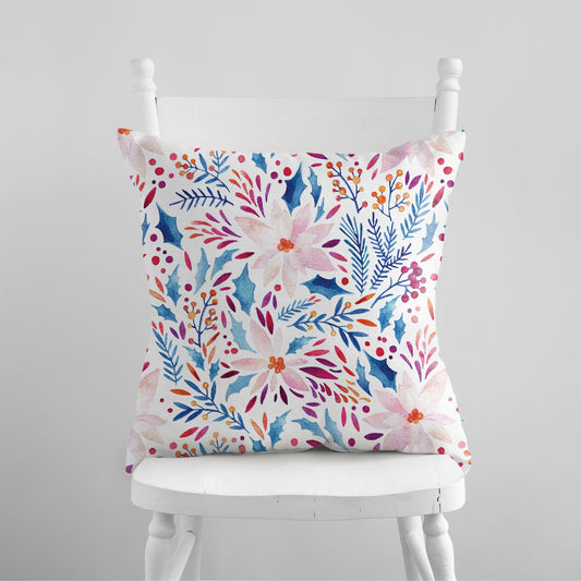 Watercolor pink poinsettia and blue botanical pillow on white chair – soft winter holiday decor