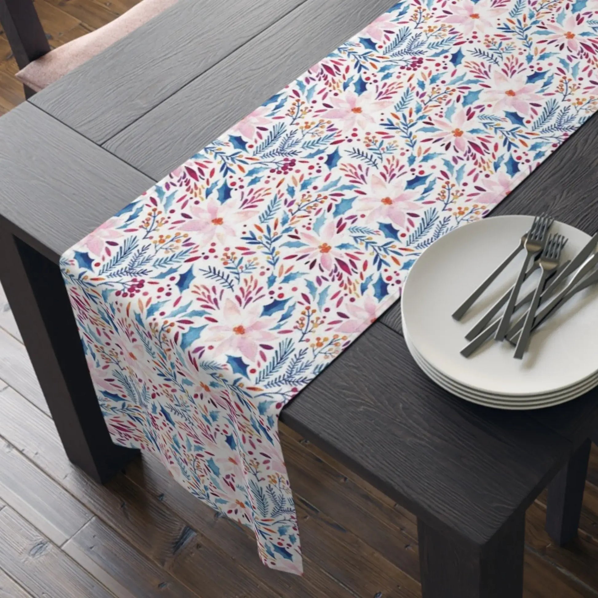 Pink Poinsettia Winter Table Runner featuring vibrant floral patterns on a rustic wooden dining table.