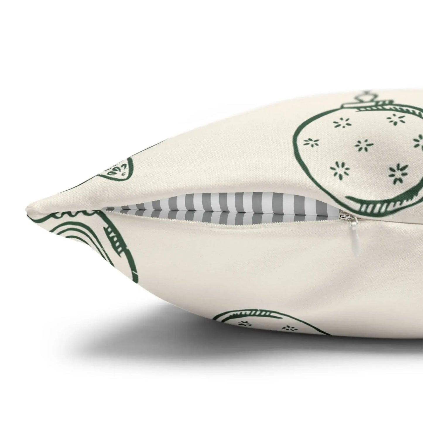 Close-up of Retro Christmas Pillow zipper, featuring green wreaths and vintage ornaments on ivory fabric.