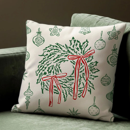 Retro Christmas Pillow with green wreaths and red bows, vintage holiday decor on soft ivory fabric.