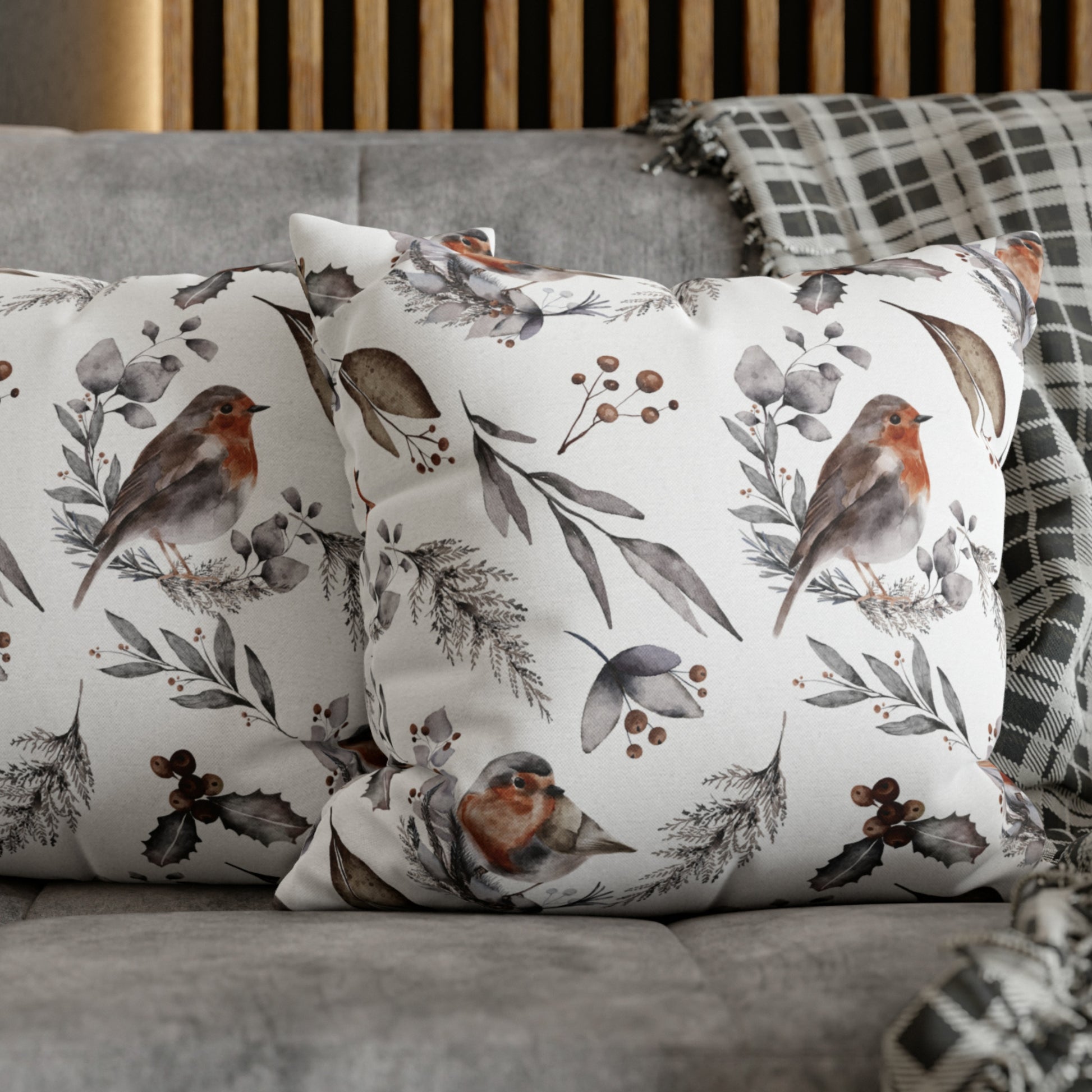 Winter robin bird pillows on a grey couch with plaid throw blanket – cozy seasonal decor