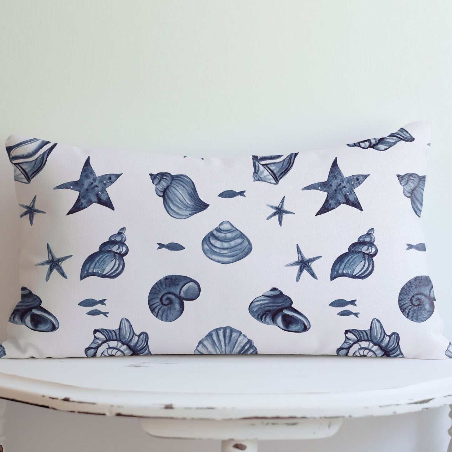 seashell lumbar pillow on white vintage table