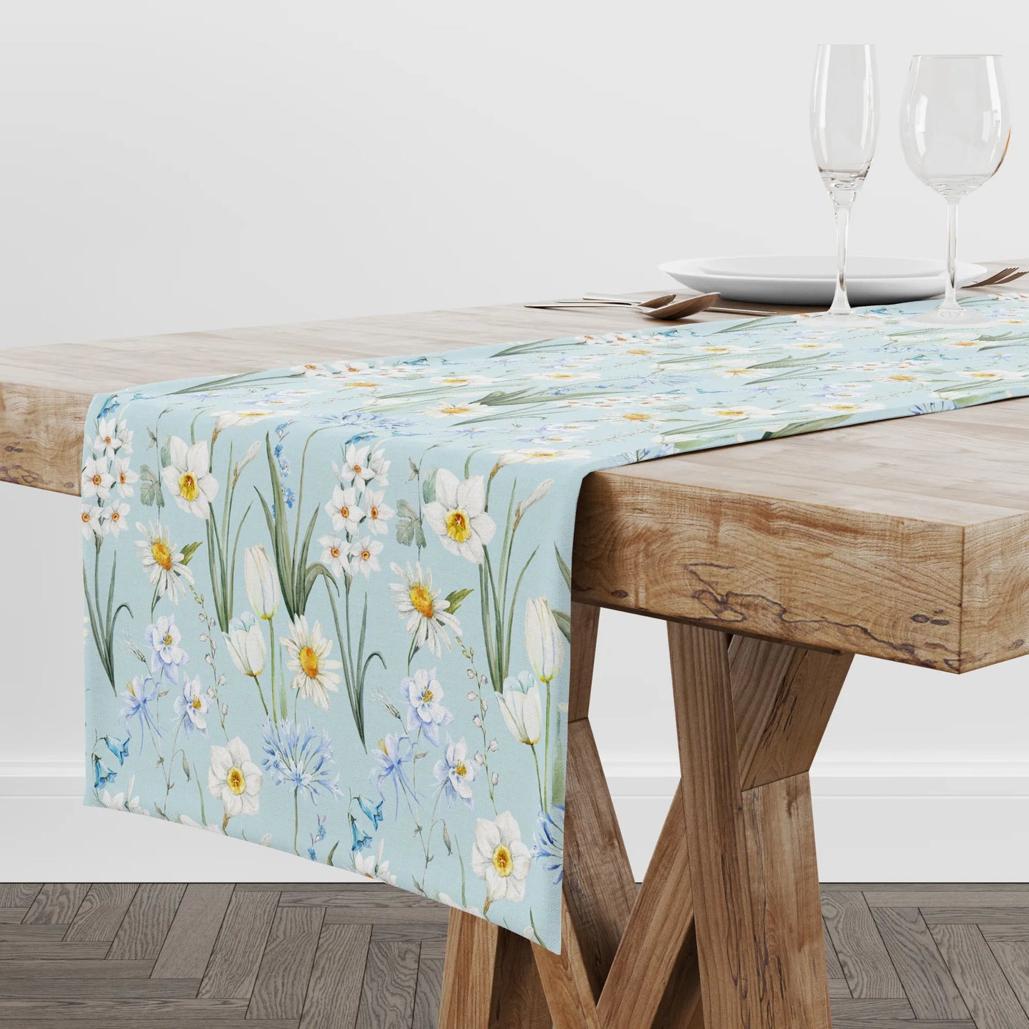 Spring Meadow Table Runner on a wooden table, featuring watercolor flowers in soft shades of blue, white, and green.