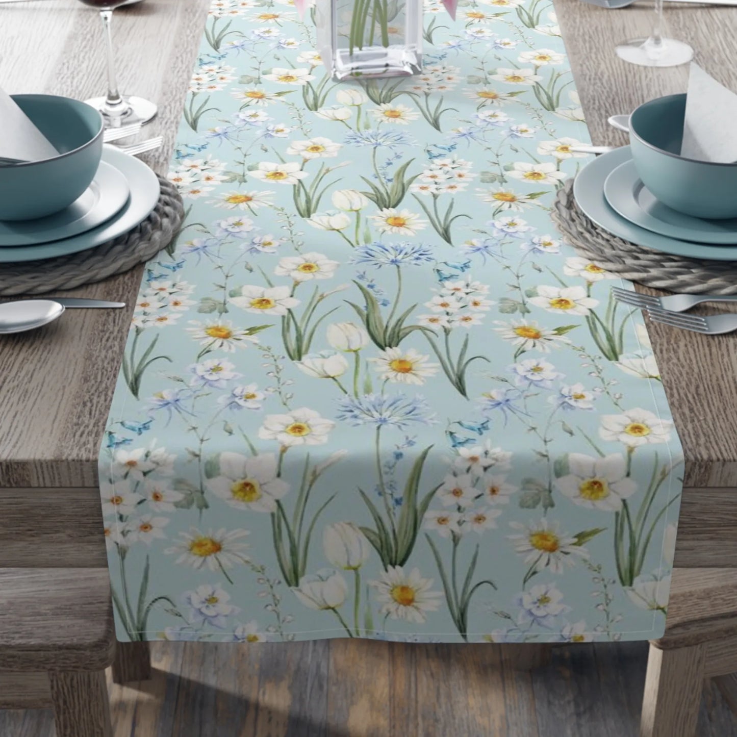 Spring Meadow Table Runner displayed on a dining table with a soft blue background and delicate watercolor flowers.