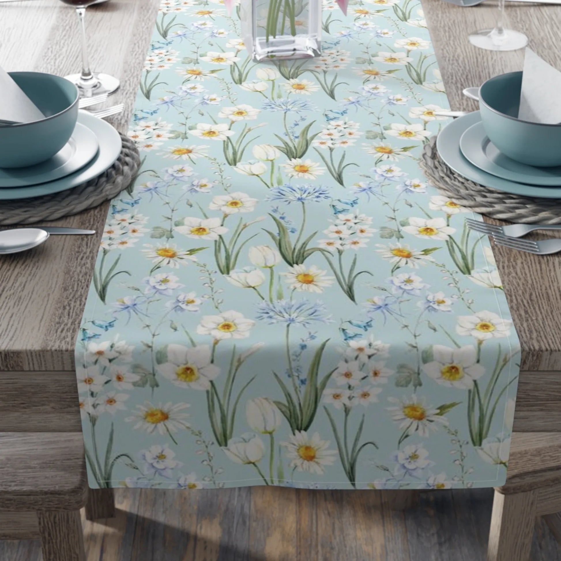 Spring Meadow Table Runner displayed on a dining table with a soft blue background and delicate watercolor flowers.