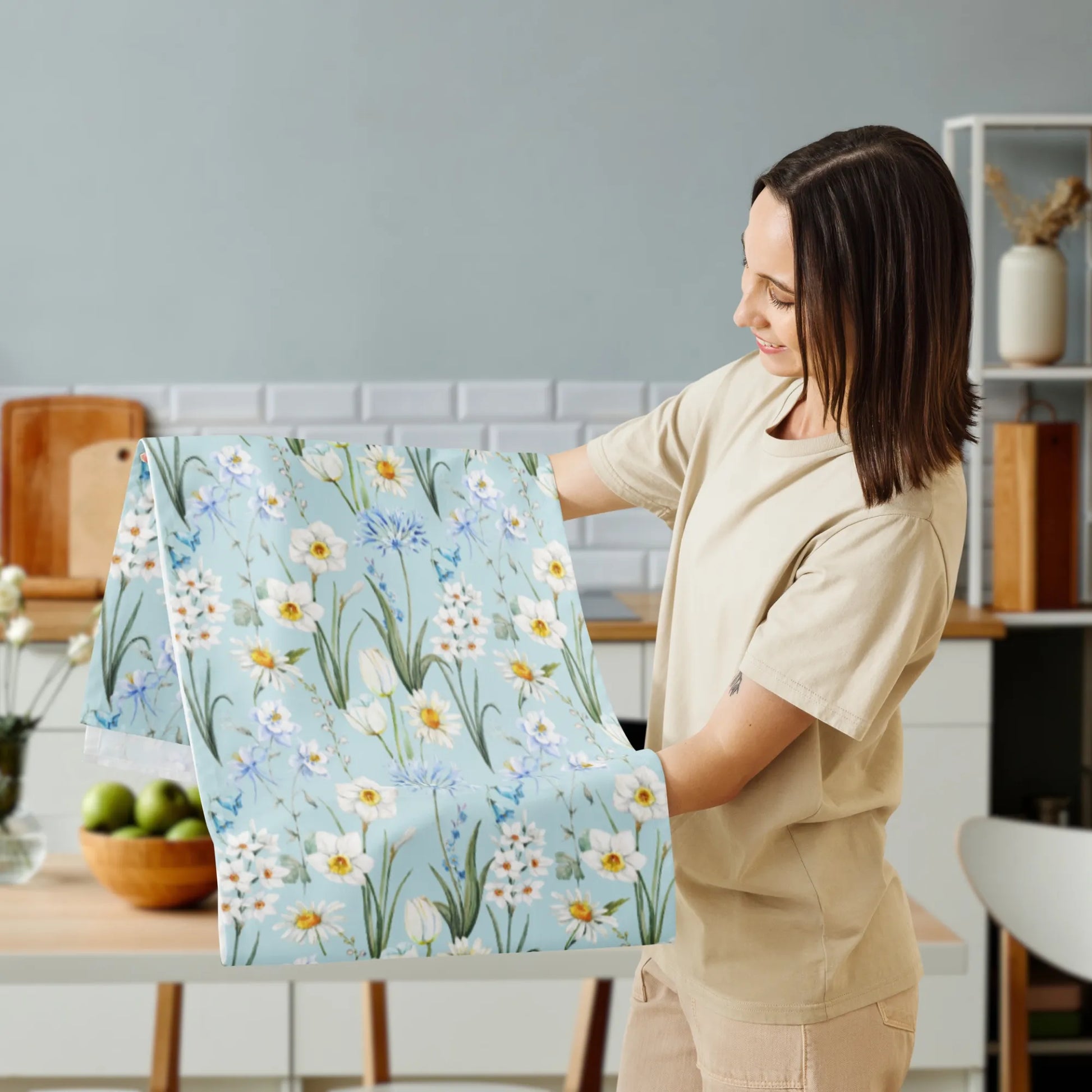 Spring Meadow Table Runner held up by a woman, showcasing watercolor flowers in soft blue, white, and green hues, perfect for spring decor.