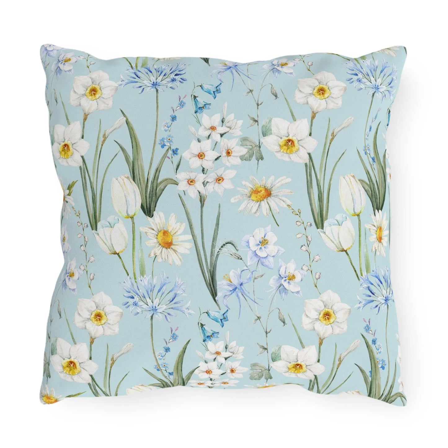 Square pillow with watercolor blue background and spring wildflowers including daffodils, daisies, and tulips.