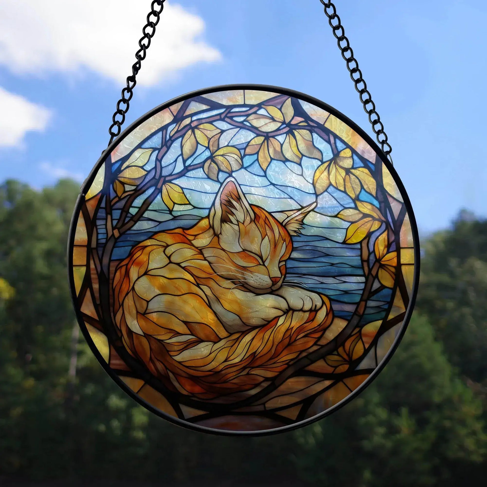 Round stained glass cat ornament with autumn leaves and blue sky background