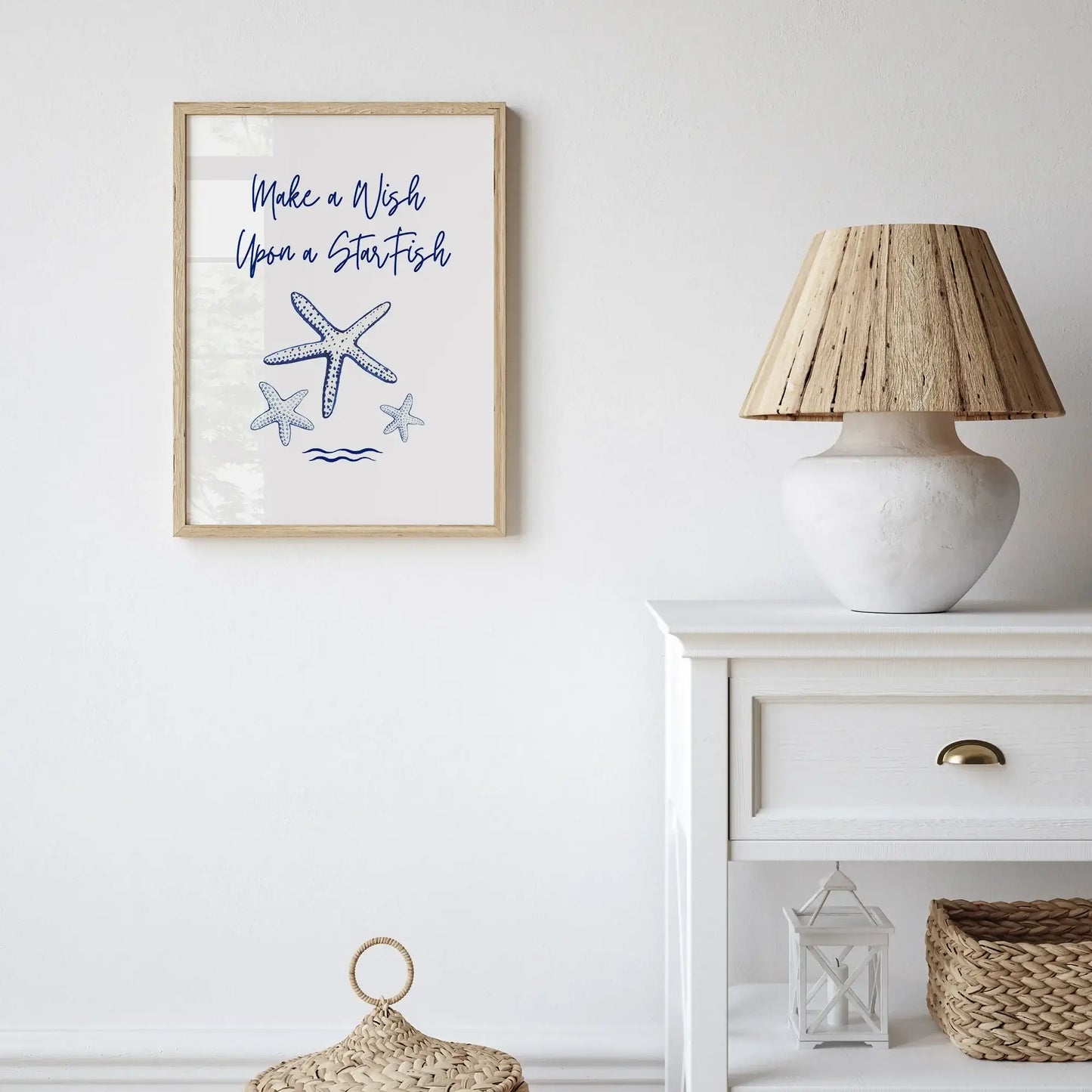 Coastal-themed room featuring a framed "Make a Wish Upon a Starfish" printable wall art with navy blue starfish, styled with neutral decor accents.