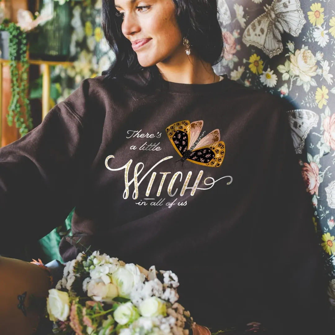 beautiful dark woman wearing Moth Witch SWEATSHIRTS from Blue Water Songs with moth backdrop behind