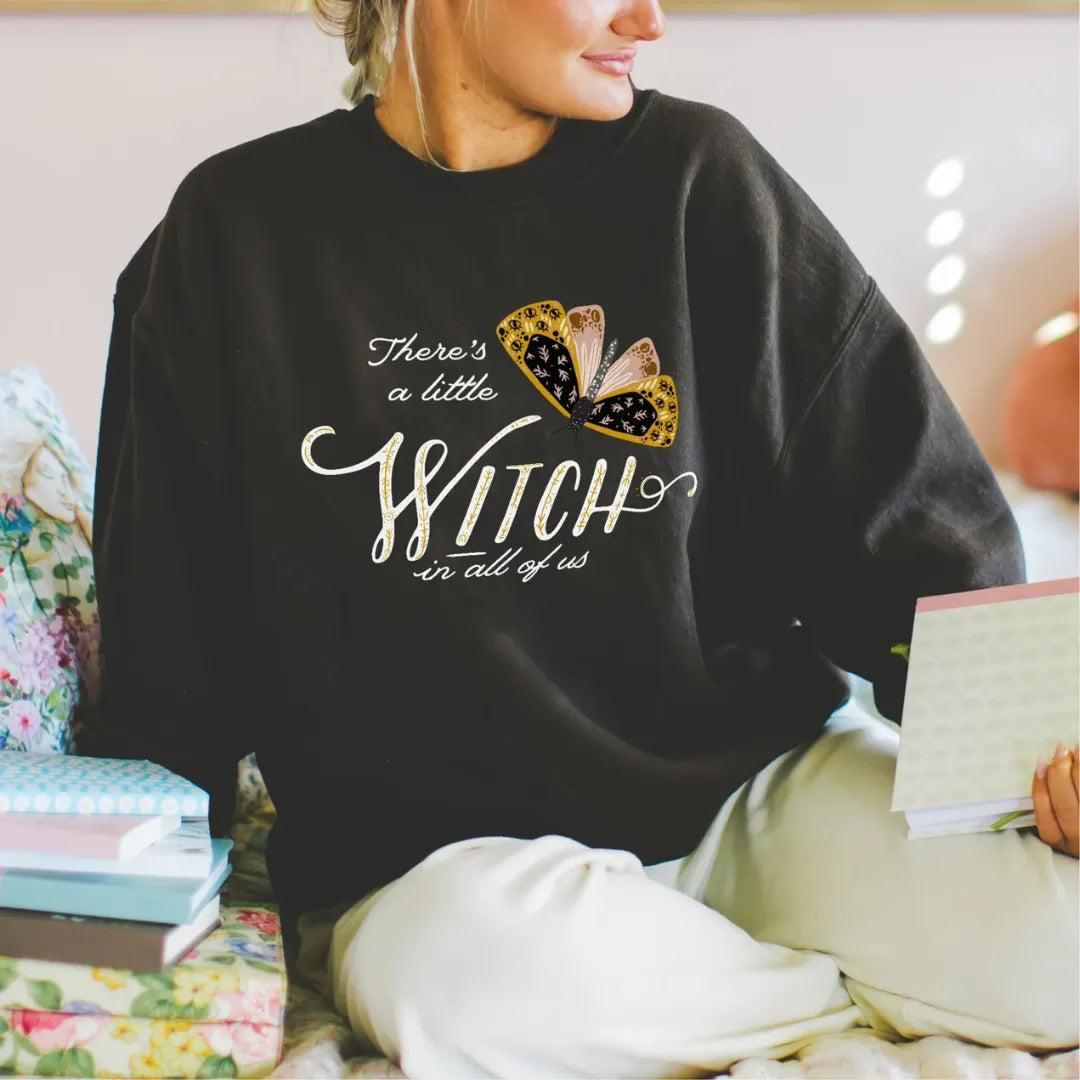 woman on Moth Witch SWEATSHIRTS from Blue Water Songs sitting with the book on hand