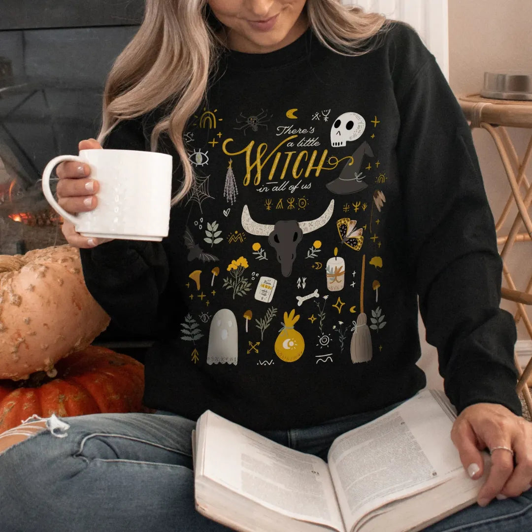 woman wearing There's a little witch SWEATSHIRTS from Blue Water Songs reading book