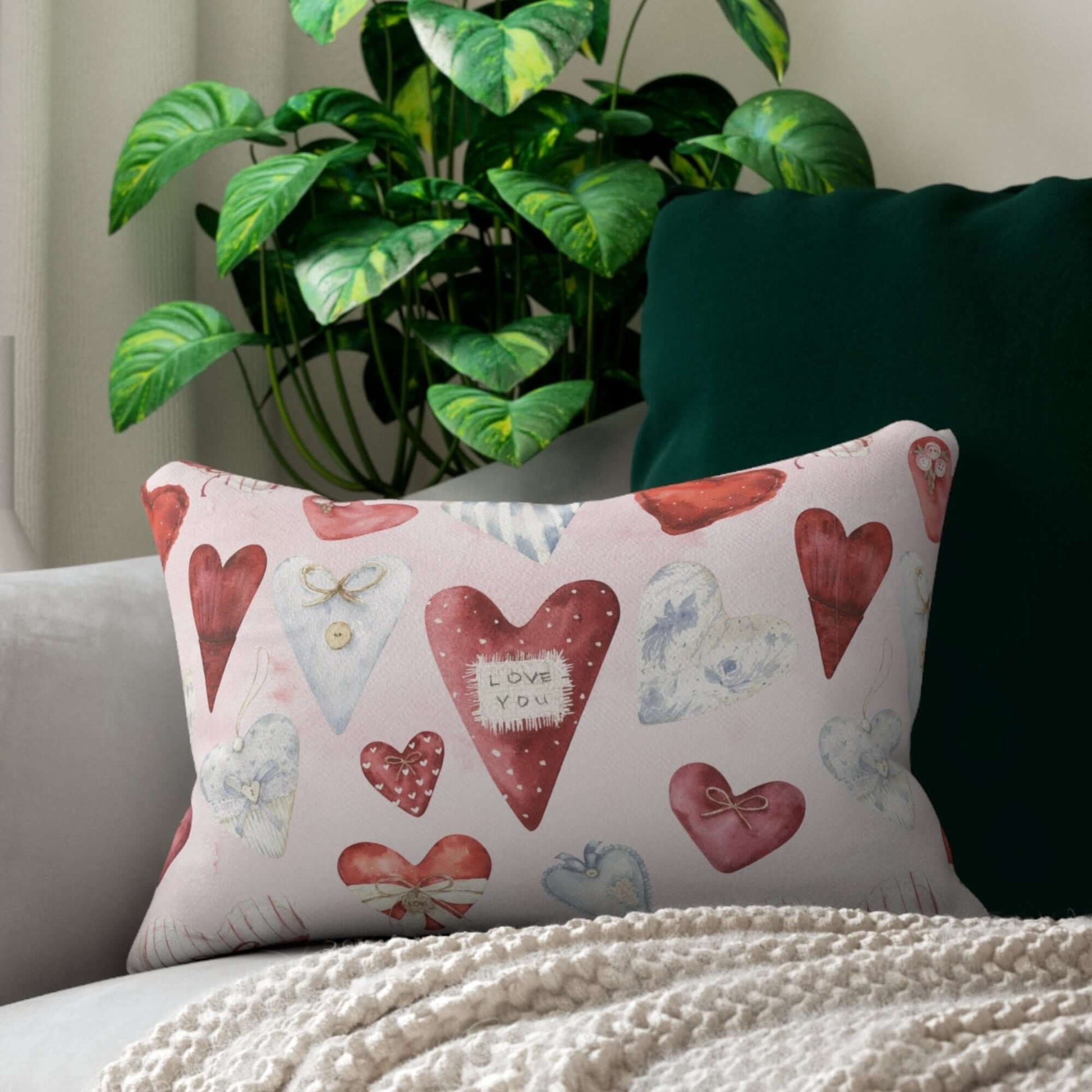 Vintage hearts Valentine pillow styled with greenery, featuring watercolor hearts in red and blue tones.
