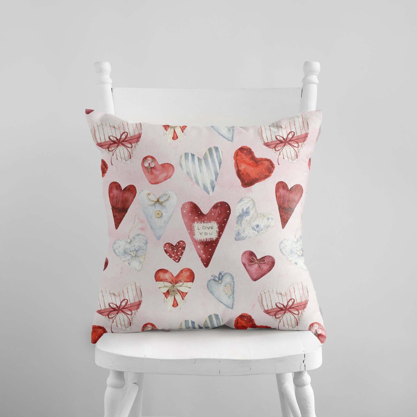 Vintage hearts Valentine pillow with watercolor red and blue heart pattern on soft blue background.
