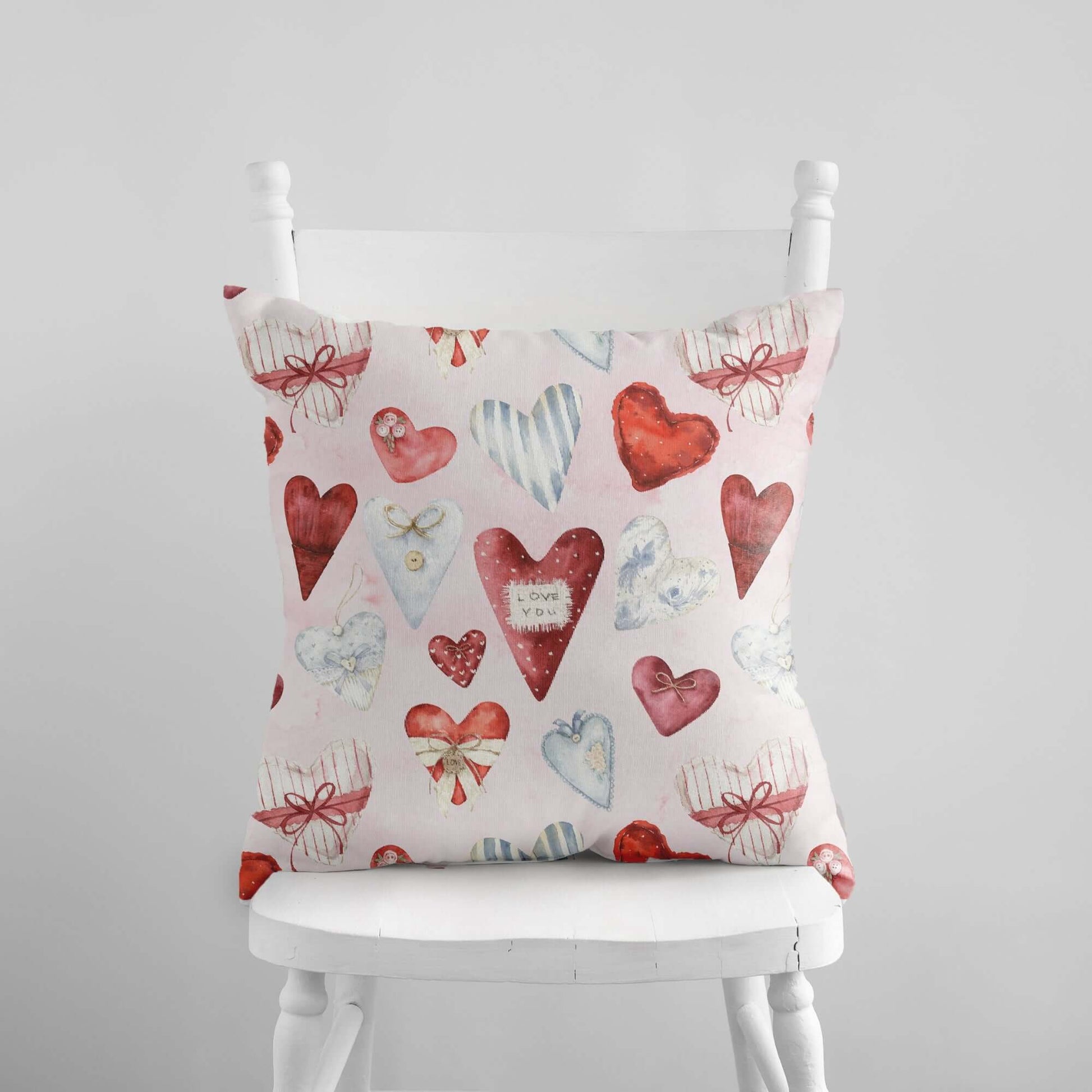 Vintage hearts Valentine pillow with watercolor red and blue heart pattern on soft blue background.