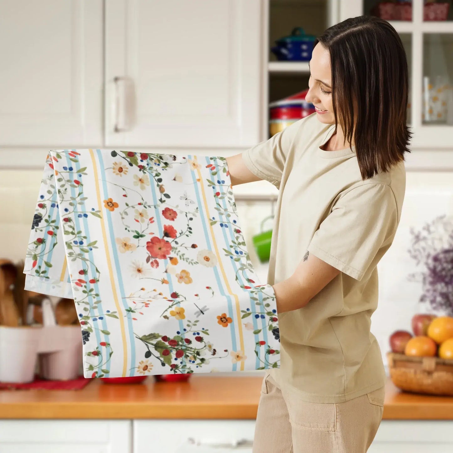 A woman showcasing a Watercolor Berry Botanical TABLE RUNNER with floral designs in a kitchen setting.