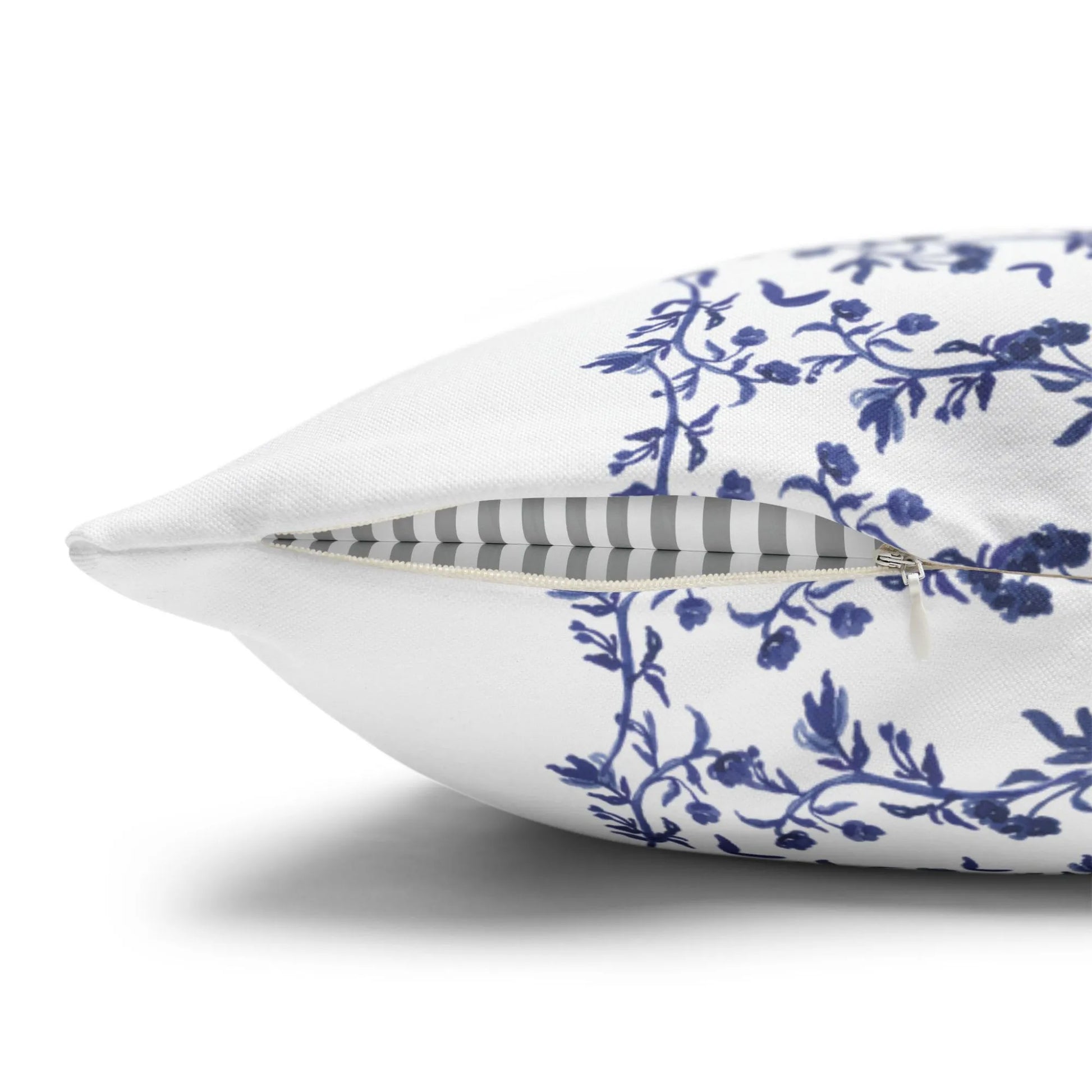 Side view of a white pillow cover with a blue Chinoiserie floral and rabbit design, showing the zipper closure.