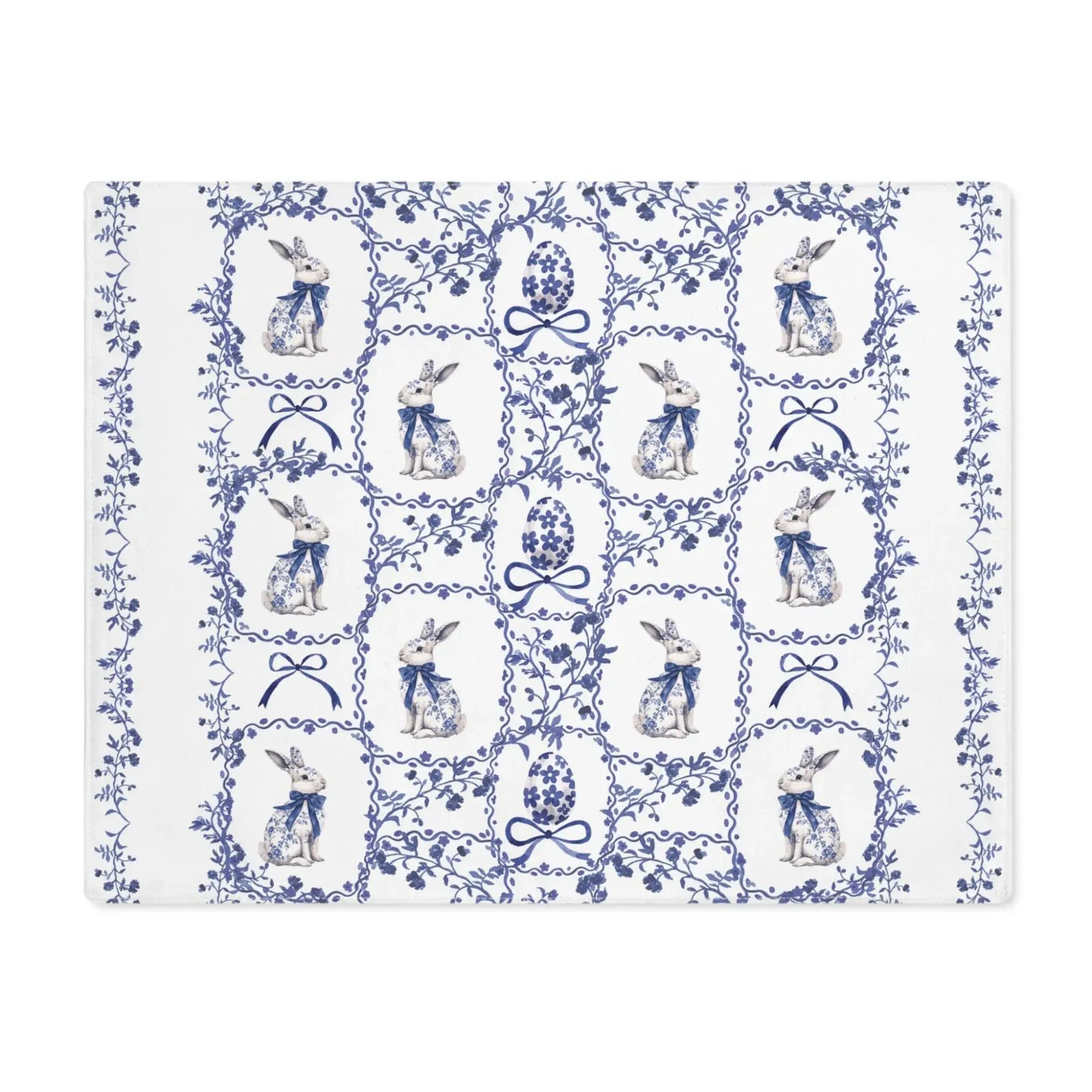 White cotton placemat with a blue watercolor Chinoiserie pattern of rabbits, Easter eggs, and delicate florals.
