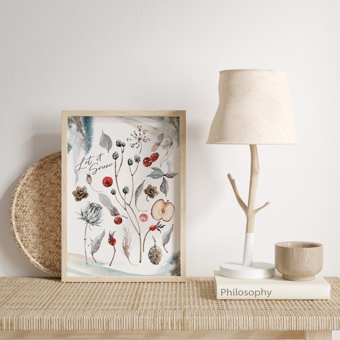 Botanical Christmas print art displayed on a table with a lamp and decor, showcasing watercolor plants and flowers.